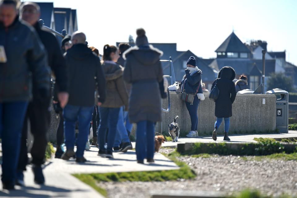 People enjoy the Spring sunshine on the seafront at Whitstable, east of London on Mother's Day, March 22, 2020. - Up to 1.5 million vulnerable people in Britain, identified as being most at risk from the coronavirus epidemic, should stay at home for at least 12 weeks, the government said Sunday. (Photo by Ben STANSALL / AFP) (Photo by BEN STANSALL/AFP via Getty Images)