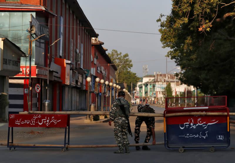Indian Central Reserve Police Force officers put up a roadblock on an empty street during a lockdown on the first anniversary of the revocation of Kashmir's autonomy in Srinagar