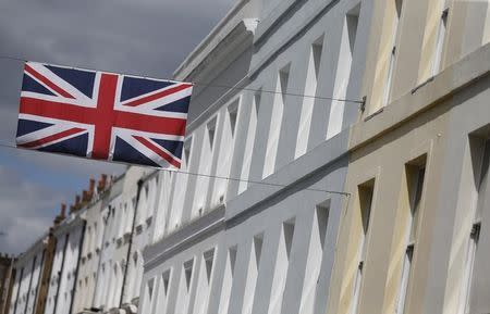 A Union flag hangs across a street of houses in London, Britain June 3, 2015. REUTERS/Suzanne Plunkett