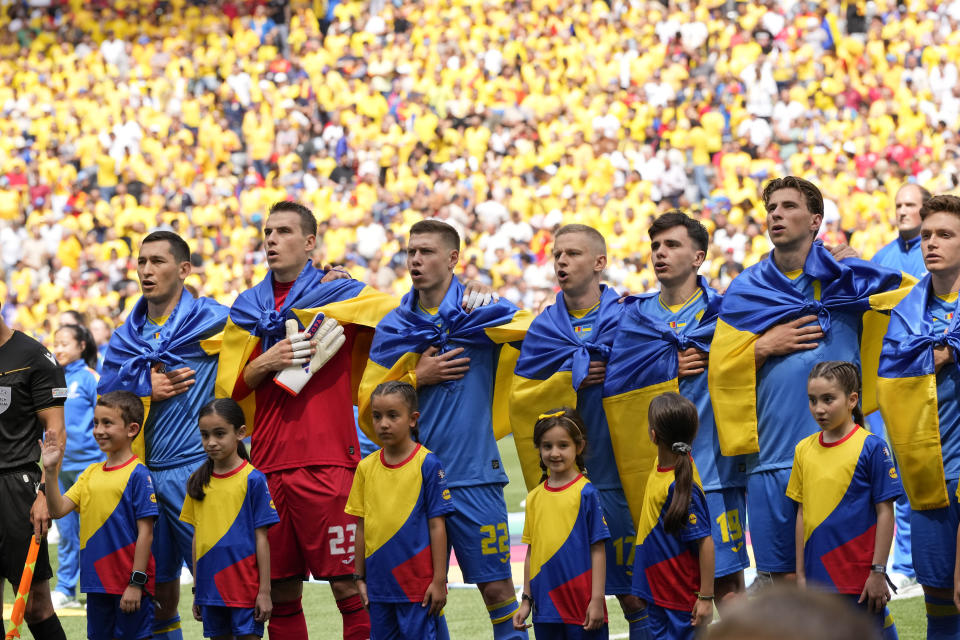 Ukrainian players sing their national anthem prior to a Group E match between Romania and Ukraine at the Euro 2024 soccer tournament in Munich, Germany, Monday, June 17, 2024. (AP Photo/Antonio Calanni)