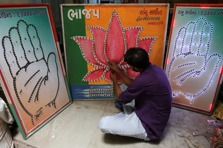 FILE PHOTO: An electrician tests LED-light fitted boards with symbols of India's ruling Bharatiya Janata Party and main opposition Congress party at a workshop in Ahmedabad, India, April 15, 2019. REUTERS/Amit Dave