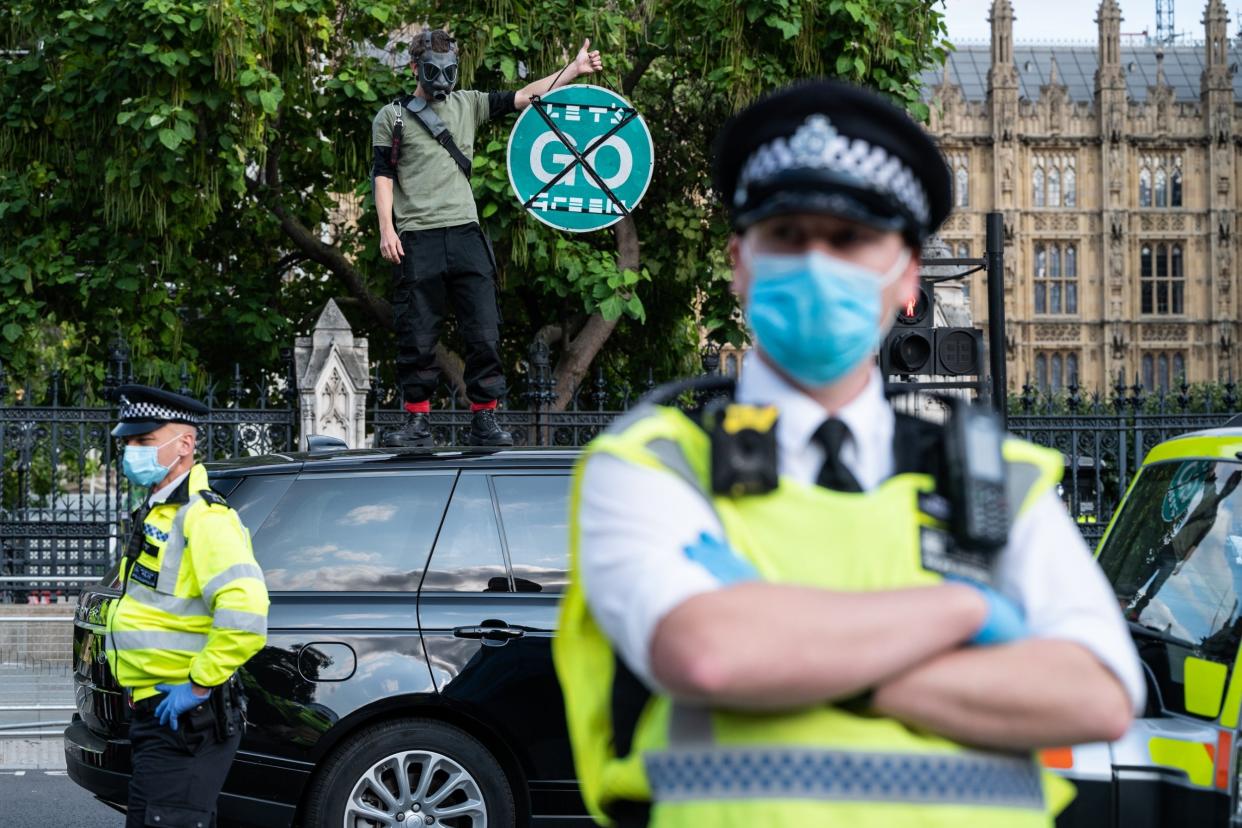 An Extinction Rebellion demonstrator stands on top of a car as traffic comes to a stop in Parliament Square: Getty Images