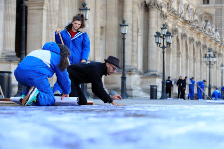French artist JR works in the courtyard of the Louvre Museum near the glass pyramid designed by Ieoh Ming Pei as the Louvre Museum celebrates the 30th anniversary of its glass pyramid in Paris, France, March 26, 2019. REUTERS/GonzaloÊFuentes