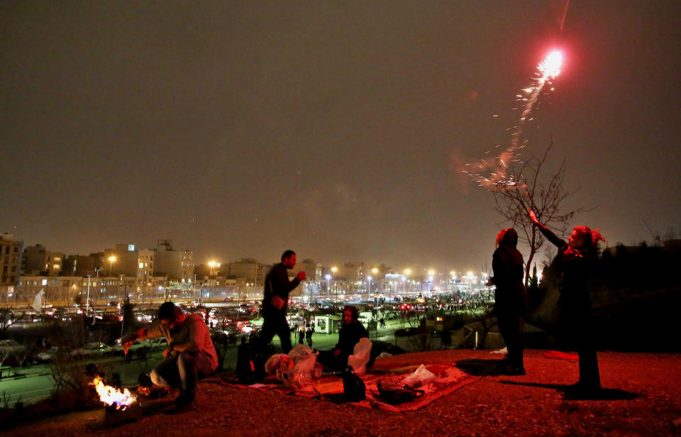 In this picture taken on Tuesday, March 18, 2014, an Iranian woman lights fireworks during a celebration, known as “Chaharshanbe Souri,” or Wednesday Feast, marking the eve of the last Wednesday of the solar Persian year, in Pardisan park, Tehran, Iran. March 21, the first day of spring, marks Nowruz, the beginning of the year 1393 on the Persian calendar. (AP Photo/Ebrahim Noroozi)