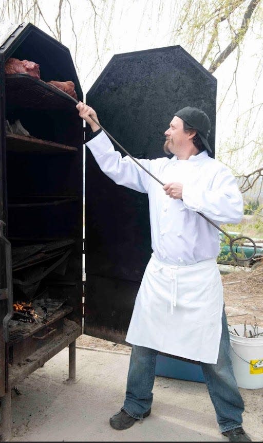 Scott Edward Signori loads meat into a smoker in this undated picture.