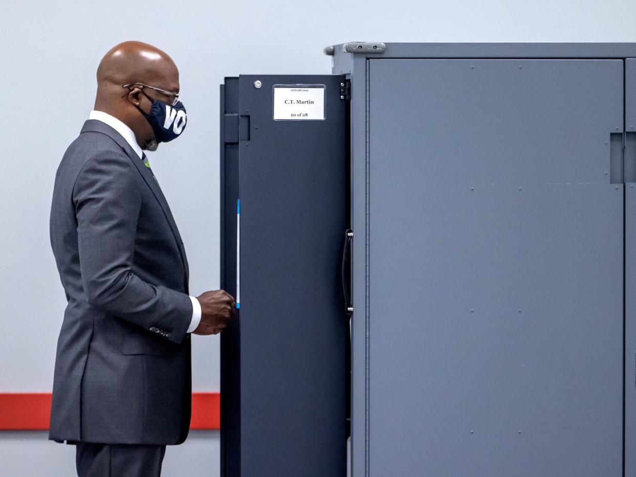 <p>Democratic US Senate candidate Raphael Warnock casts his ballot on the first day of voting in the Georgia runoffs</p> (EPA)
