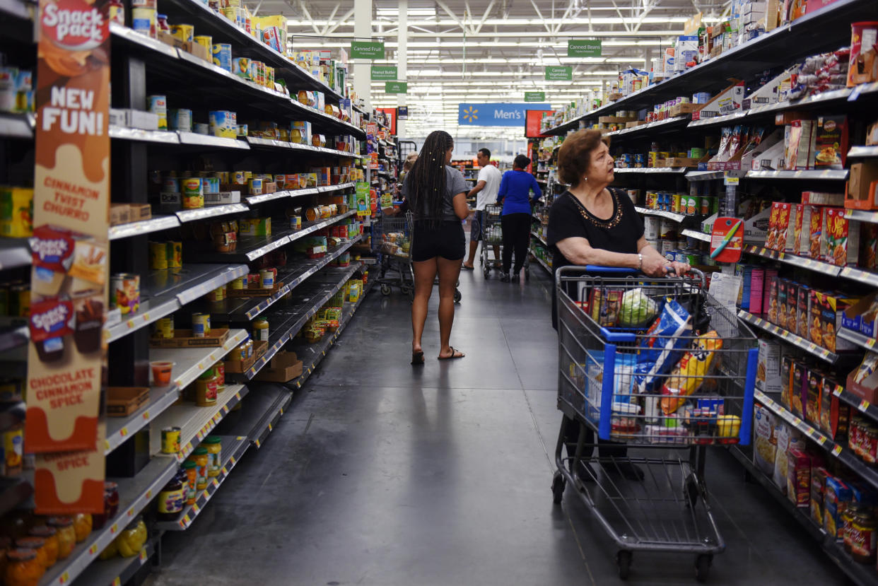 Shoppers walk through a depleted canned food aisle in a Walmart store in Charlotte, North Carolina, as residents prepare Thursday for Hurricane Florence. (Photo: Bloomberg via Getty Images)