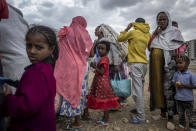 Elena, 7, center, stands in line with other displaced Tigrayans to receive food donated by local residents at a reception center for the internally displaced in Mekele, in the Tigray region of northern Ethiopia, on Sunday, May 9, 2021. In farming areas in Tigray to which The Associated Press got rare access, farmers, aid workers and local officials confirmed that food had been turned into a weapon of war. (AP Photo/Ben Curtis)