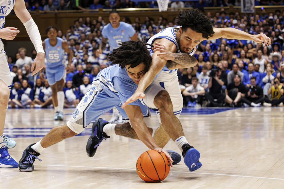 Duke's Jared McCain, right, and North Carolina's Elliot Cadeau, left, battle for a loose ball during the first half of an NCAA college basketball game in Durham, N.C., Saturday, March 9, 2024. (AP Photo/Ben McKeown)
