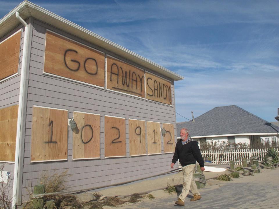 In this Thursday, Nov. 1, 2012 photo, a man walks along the Point Pleasant Beach, N.J. boardwalk, where Superstorm Sandy was an unwelcome visitor . The storm wrecked boardwalks and amusements up and down the 127-mile Jersey shore. (AP Photo/Wayne Parry)