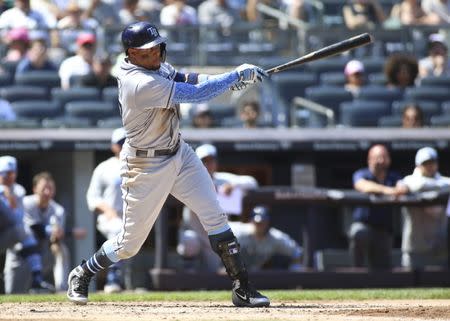 Jun 17, 2018; Bronx, NY, USA; Tampa Bay Rays left fielder Carlos Gomez (27) hits a single in the fourth inning against the New York Yankees at Yankee Stadium. Mandatory Credit: Wendell Cruz-USA TODAY Sports