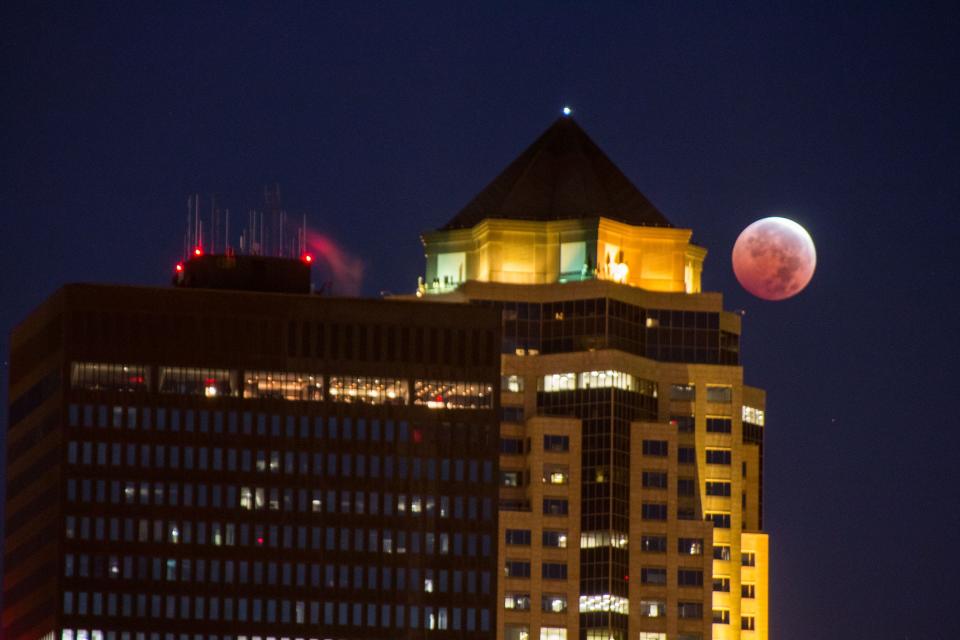 The blood moon is visible behind 801 Grand in downtown Des Moines on Oct. 8, 2014
