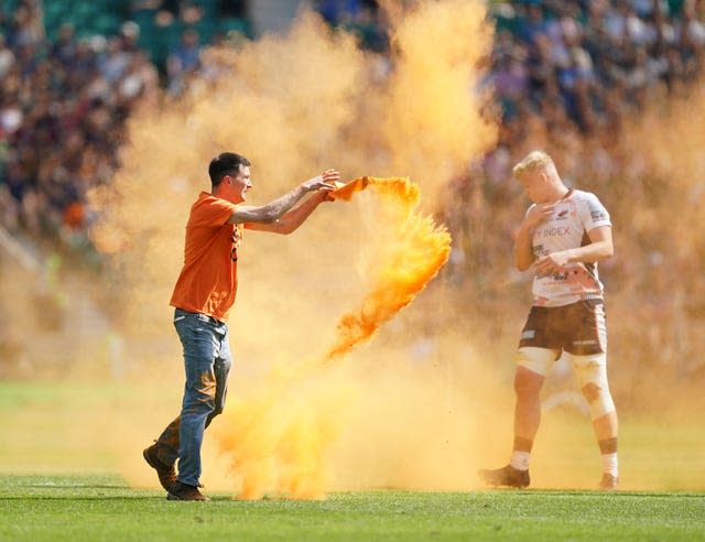 A Just Stop Oil protestor throws orange powder on the pitch during the Gallagher Premiership final at Twickenham