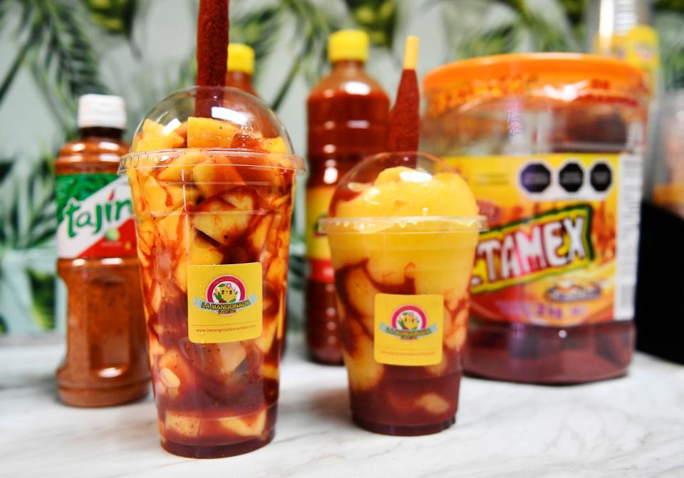 A mangonada, left, and chamoyada made by La Mangonada Snack Bar owner Nuria Miranda in Pennsauken, N.J. Each are served with a tamarind candy straw rolled in chili powder. July 14, 2022.