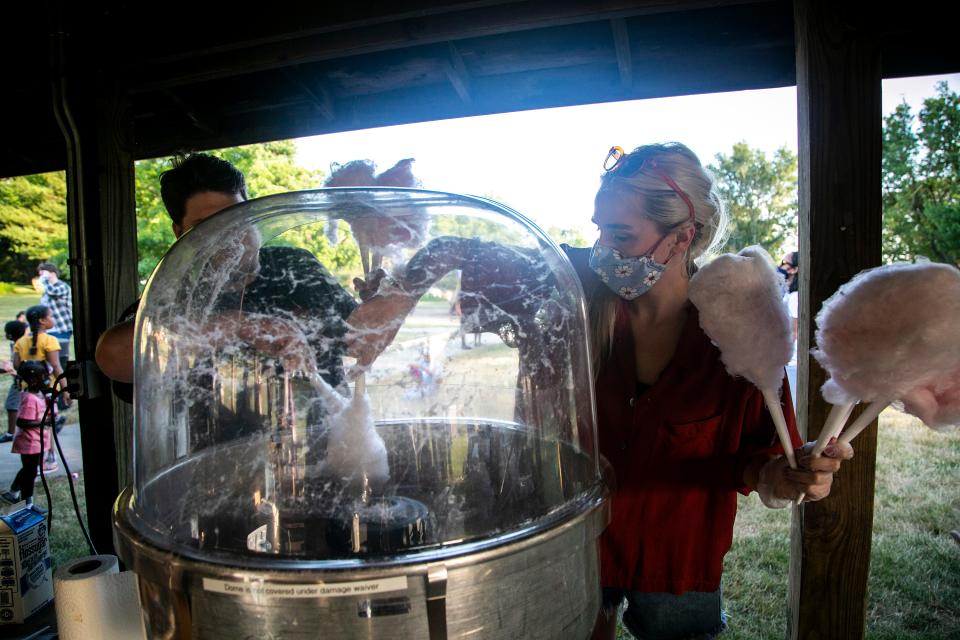 Jee Michales, left, and Bailey Baker prepare sticks of cotton candy during an event organized by the Iowa Freedom Riders on Juneteenth, Saturday, June 19, 2021, at S.T. Morrison Park in Coralville, Iowa.