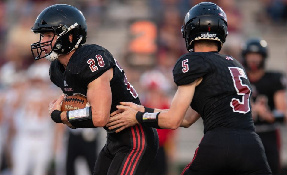 Southridge's Reid Schroeder (28) is handed off the ball by Southridge's Hudson Allen (5) as the Southridge Raiders play the Gibson Southern Titans at Southridge High School in Huntingburg, Ind., Friday evening, Sept. 16, 2022. 