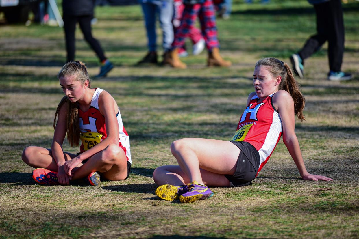 Maggie Kuchman, left, and Annabelle Lynch are left exhausted after completing the course at Devens on Saturday in the Div. 2 state cross country championship. Kuchman placed seventh and Lynch 13th as the Panthers repeated as team champs.