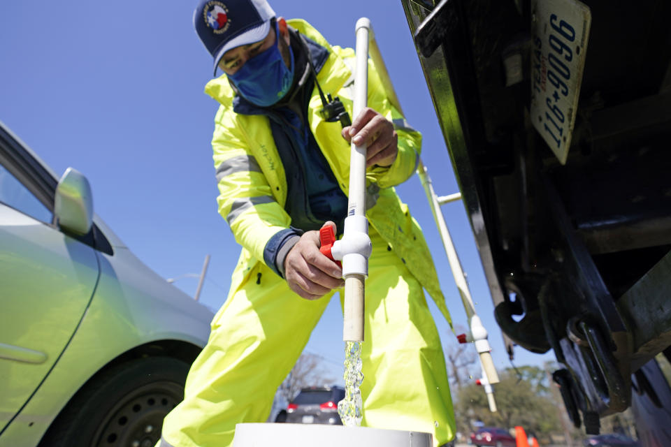 Harris County Precinct 4 employee Hector Plascencia fills containers with non-potable water at a water distribution site Friday, Feb. 19, 2021, in Houston. Houston and surrounding cities remain under a boil water notice as many residents lack water at home due to frozen or broken pipes. (AP Photo/David J. Phillip)