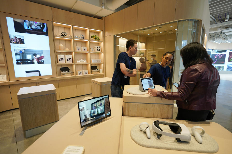 A woman examines the Meta Portal Go during a preview of the Meta Store in Burlingame, Calif., Wednesday, May 4, 2022. (AP Photo/Eric Risberg)