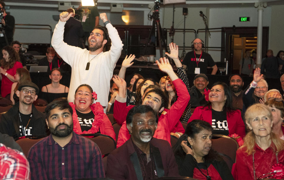 New Zealand Labour Party supporters react as results are showed on a screen at a party event after the polls closed in Auckland, New Zealand, Saturday, Oct. 17, 2020. Polling places closed and vote counting began on election day in New Zealand on Saturday as Prime Minister Jacinda Ardern seeks a second term. (AP Photo/Mark Baker)