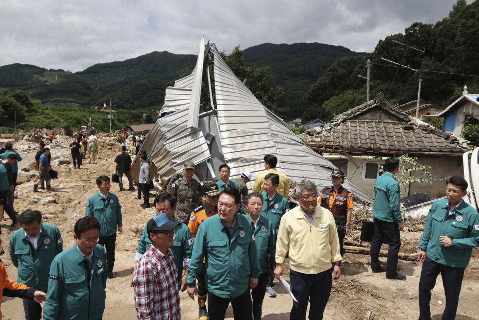 South Korean President Yoon Suk Yeol, bottom center, looks around a flood damaged area in Yecheon, South Korea, Monday, July 17, 2023. (Jin Sung-chul/Yonhap via AP)