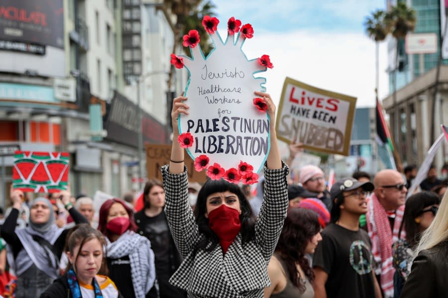 A protester holds a poster during a demonstration in support of Palestinians calling for a ceasefire in Gaza as the 96th Academy Awards Oscars ceremony is held nearby, Sunday, March 10, 2024, in the Hollywood section of Los Angeles. (AP Photo/Etienne Laurent)