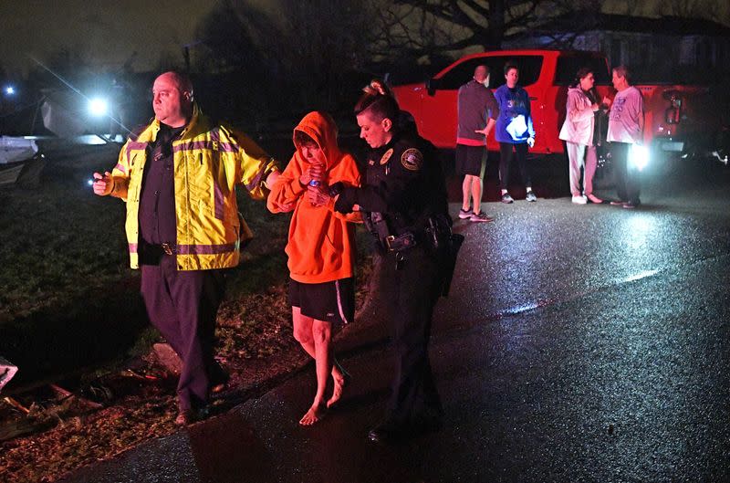 Rescue workers escort Shirley Wallace for medical attention from her Barrett Drive home after a tornado in Mt. Juliet