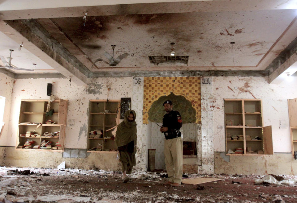 A police officer examines site of Friday's bomb explosion inside a mosque in Quetta, Pakistan, Saturday, Jan. 11, 2020. A powerful explosion ripped through a mosque in Quetta, the provincial capital of Baluchistan province, during the evening prayers on Friday, killing a senior police officer and other some people and wounded many worshipers. (AP Photo/Arshad Butt)