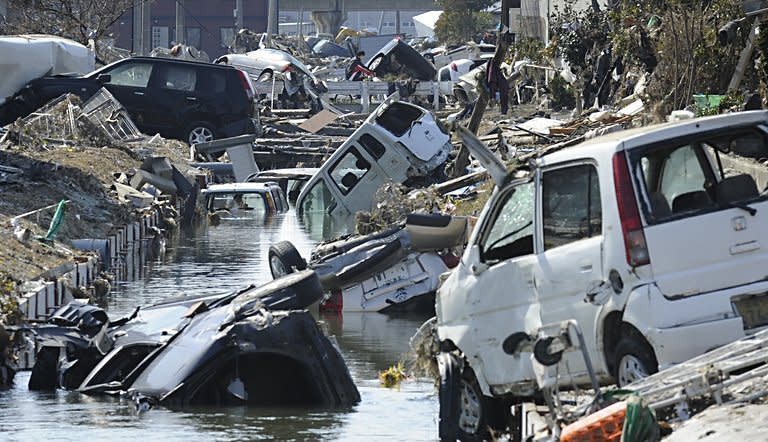 Vehicles block a canal after they were deposited there in Tagajo in Miyagi prefecture. Japan raced to avert a meltdown of two reactors at a quake-hit nuclear plant Monday as the death toll from the disaster on the ravaged northeast coast was forecast to exceed 10,000