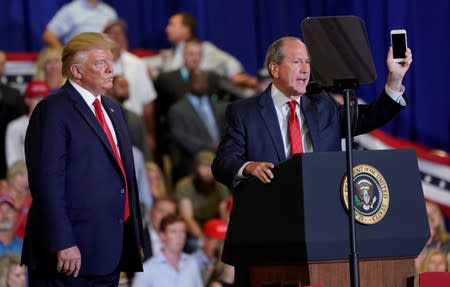 North Carolina’s 9th District Republican candidate Dan Bishop holds up his phone as U.S. President Donald Trump holds a campaign rally in Fayetteville, North Carolina