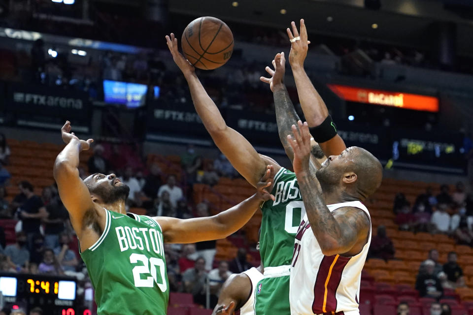 Miami Heat forward P.J. Tucker, right, shoots as Boston Celtics forwards Jabari Parker (20) and Jayson Tatum (0) defend during the first half of a preseason NBA basketball game, Friday, Oct. 15, 2021, in Miami. (AP Photo/Lynne Sladky)