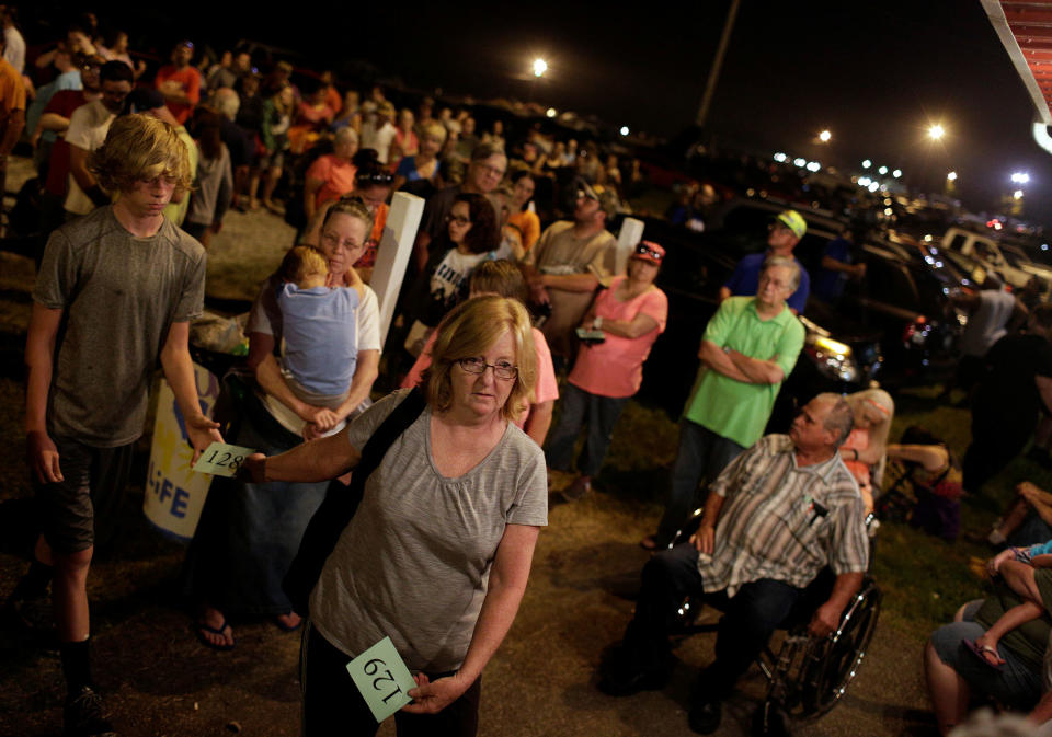 A woman displays her number in line