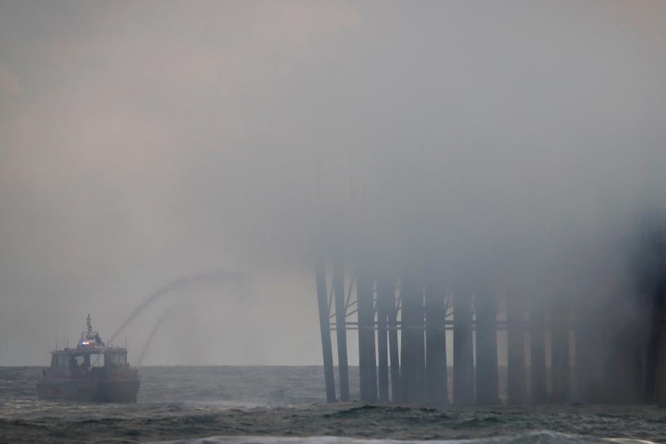 Firefighters try to extinguish a fire burning Thursday on the West end of the Oceanside Pier, in Oceanside, California.