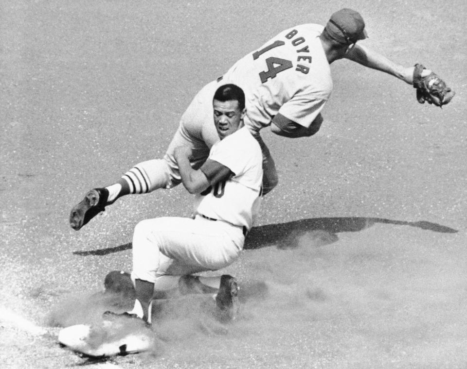 Los Angeles Dodgers' Maury Wills is safe at third as St. Louis Cardinals' Ken Boyer takes the throw during the first inning of a baseball game in Los Angeles, Sept. 26, 1965. Maury Wills, who helped the Los Angeles Dodgers win three World Series titles with his base-stealing prowess, has died. The team says Wills died Monday night, Sept. 19, 2022, in Sedona, Ariz. He was 89. 