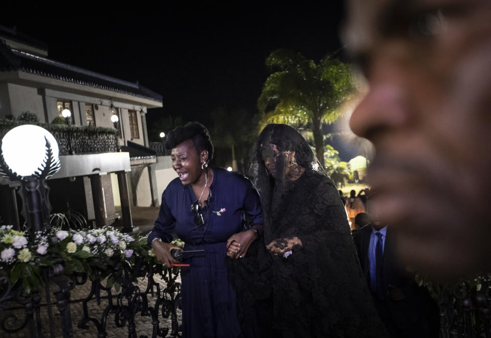 Widow Grace Mugabe, center, wears a black veil as she follows the coffin of former president Robert Mugabe, as it arrives to lie in state inside his official residence in the capital Harare, Zimbabwe Wednesday, Sept. 11, 2019. Zimbabwe's founding leader Robert Mugabe made his final journey back to the country Wednesday, his body flown into the capital amid the contradictions of his long, controversial rule. (AP Photo/Ben Curtis)