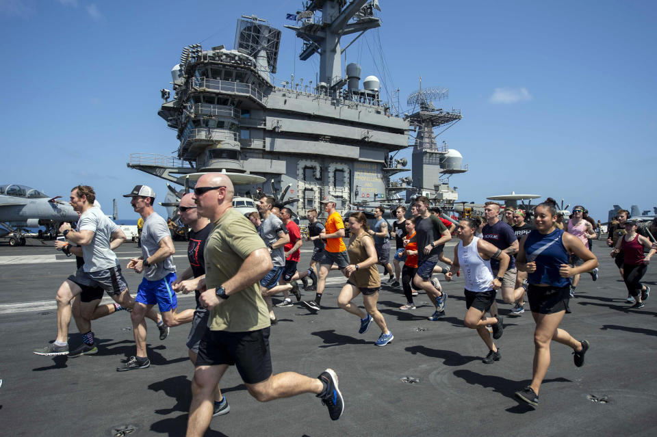 In this May 24, 2020, photo, provided by the U.S. Navy Sailors run on the flight deck aboard the aircraft carrier USS Dwight D. Eisenhower (CVN 69). When coronavirus made U.S. Navy ship stops in foreign countries too risky, the USS Dwight D Eisenhower and the USS San Jacinto were ordered to keep moving, and avoid all port visits. More than five months after they set sail, they have broken a record they never planned to achieve. As they steamed through the North Arabian Sea on June 25, they notched their 161st consecutive day at sea, breaking the previous Navy record of 160 days. (Mass Communication Specialist 3rd Class Sophie A. Pinkham/U.S. Navy via AP)