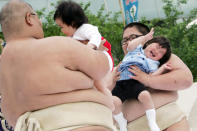 TOKYO, JAPAN - APRIL 29: Sumo wrestler students try to make babies cry during the Crying Sumo competition at Sensoji Temple on April 29, 2006 in Tokyo, Japan. The first baby that cries wins this competition. The ceremony has been taking place in Japan to wish for the good health of the child as it is said that crying is good for the health of babies. Majority of the children who participate are less than 1 year old. (Photo by Junko Kimura/Getty Images)