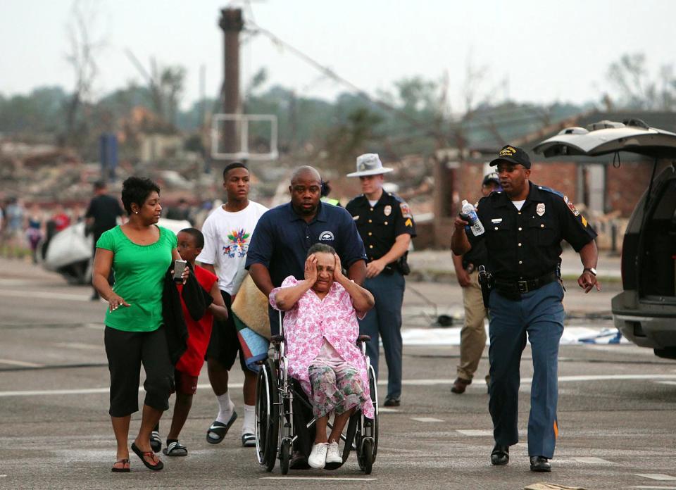 A family is assisted by emergency responders near 15th St. in Tuscaloosa, Ala. Wednesday, April 27, 2011, after a powerful tornado moved through the city.