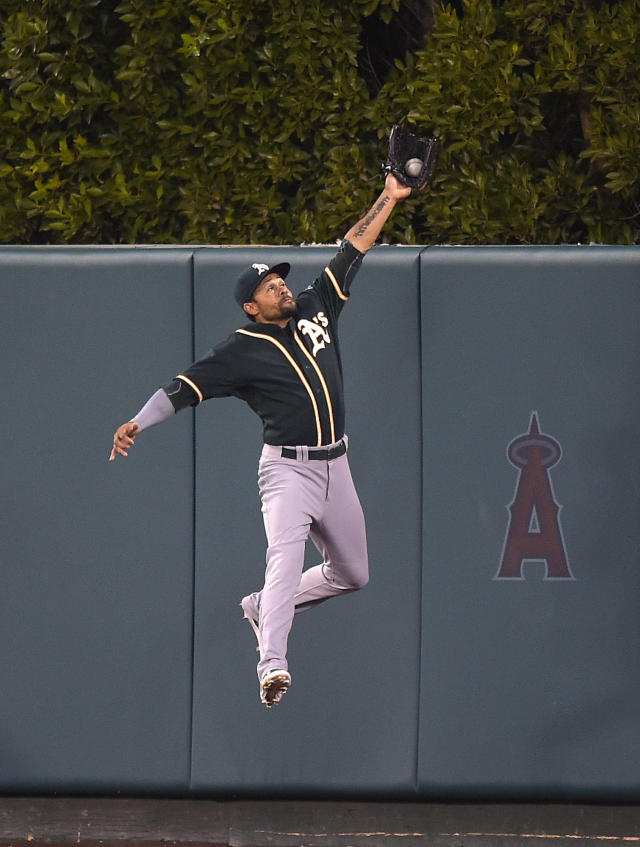 A's center fielder Coco Crisp robs Mike Trout of a hit in the third inning Monday night. (AP Photo)