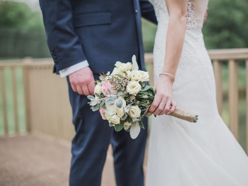 Midsection Of Newlywed Couple Standing Outdoors