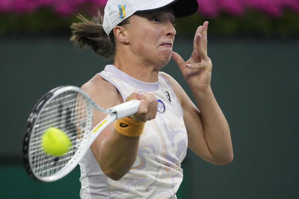 Iga Swiatek, of Poland, returns a shot to Bianca Andreescu, of Canada, at the BNP Paribas Open tennis tournament Monday, March 13, 2023, in Indian Wells, Calif. (AP Photo/Mark J. Terrill)