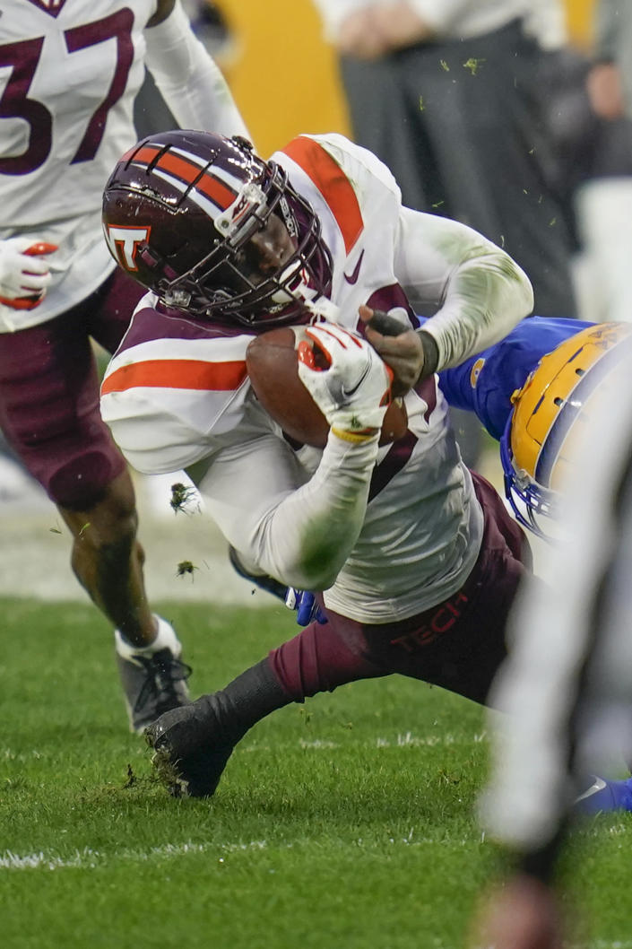 Virginia Tech defensive back Chamarri Conner (22) twists away frpom Pittsburgh wide receiver Tre Tipton (6) after intercepting a pass during the first half of an NCAA college football game, Saturday, Nov. 21, 2020, in Pittsburgh. (AP Photo/Keith Srakocic)