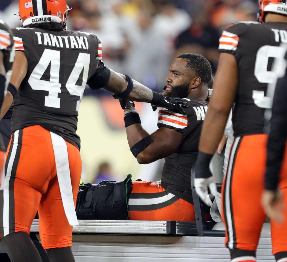 Browns linebacker Anthony Walker Jr. is comforted by teammate Sione Takitaki (44) as he is carted off the field after a second-half injury against the Pittsburgh Steelers, Thursday, Sept. 22, 2022, in Cleveland.