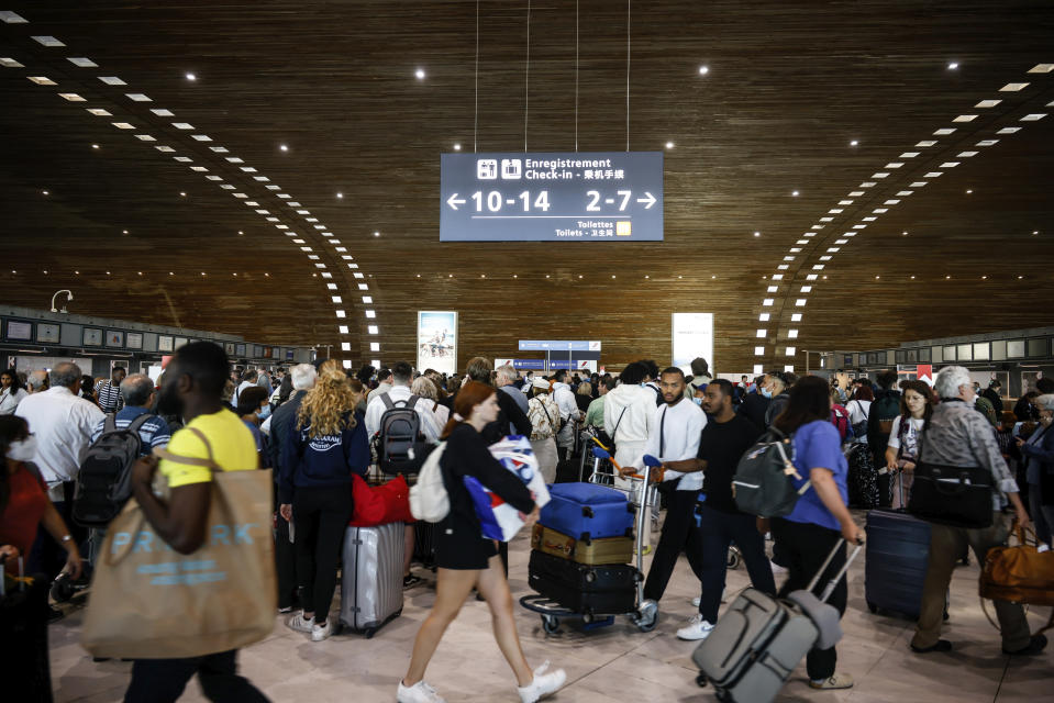 FILE - Passengers gather in a terminal of Charles de Gaulle airport, Friday, July 1, 2022 at Roissy airport, north of Paris. (AP Photo/ Thomas Padilla, File)