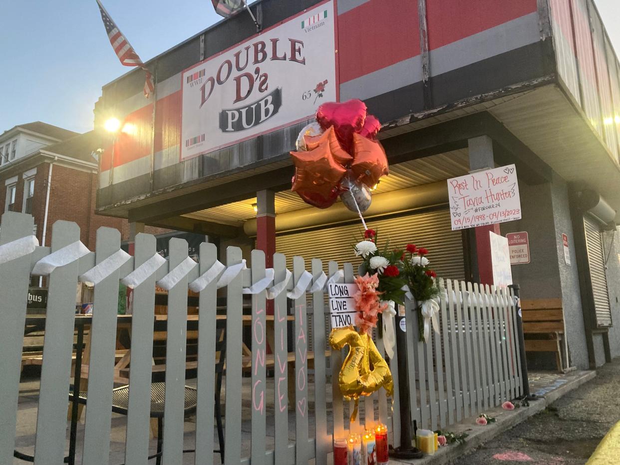 A memorial of balloons, flowers, signs and candles was erected outside Double D's Pub, 1501 S. High St., after two women were fatally shot and a man was critically wounded Sept. 13 following an altercation there. The brother of one of the two women killed is being sought by police on a warrant for murder.