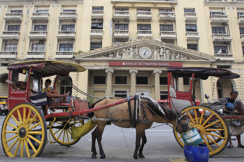 File Photo: A horse cart is parked in front of the Bank of the Philippine Islands in Manila July 1, 2014. (REUTERS/Romeo Ranoco)