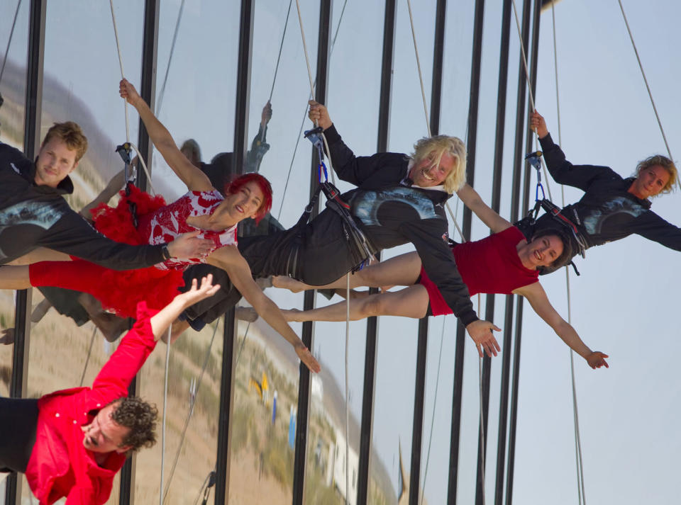 Sir Richard Branson performs with a aerial artists as he repels down the side of the new Spaceport America hangar.