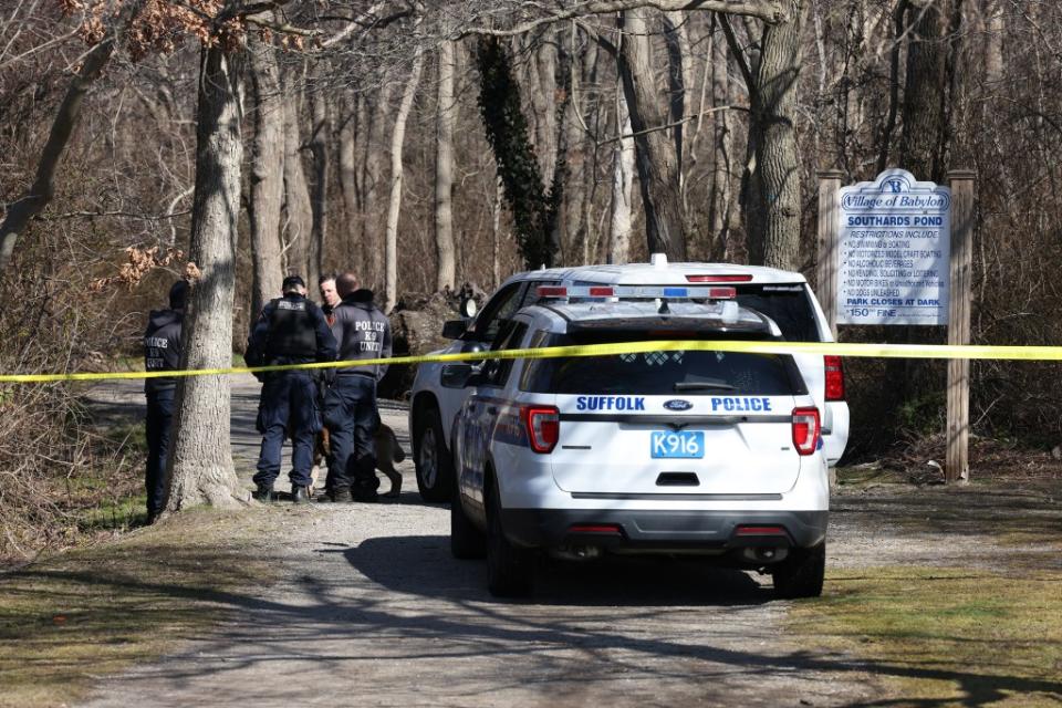 The Suffolk County police K-9 unit searches Southards Pond Park in Babylon, NY, where body parts were found. Dennis A. Clark