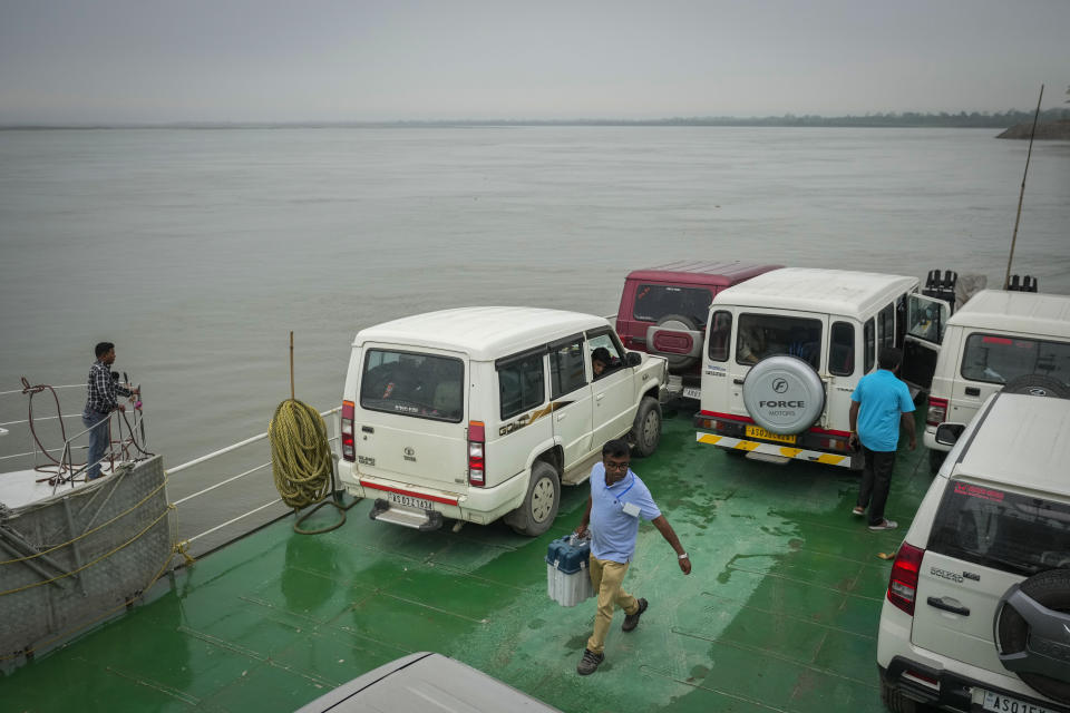 An election official walks carrying an electronic voting machine (EVM) as he prepares to disembark from a ferry after crossing the river Brahmaputra on the eve of the first phase of polling of India's national elections in Nimati Ghat, northeastern Assam state, India, Thursday, April 18, 2024. (AP Photo/Anupam Nath)