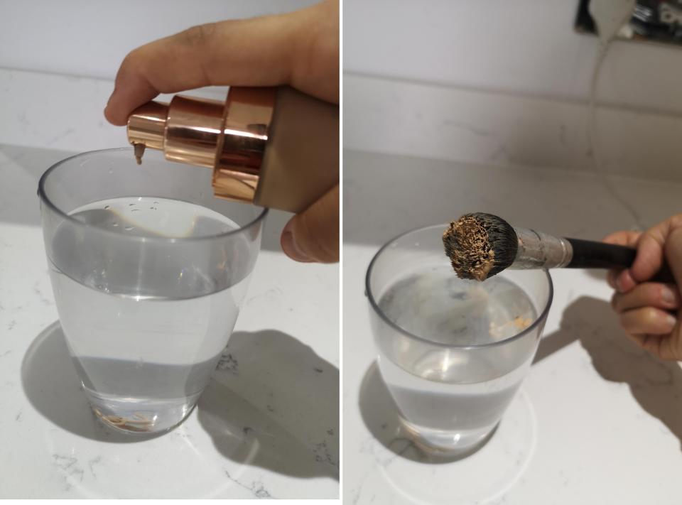 The author squirting foundation into a glass of water for a beauty hack.